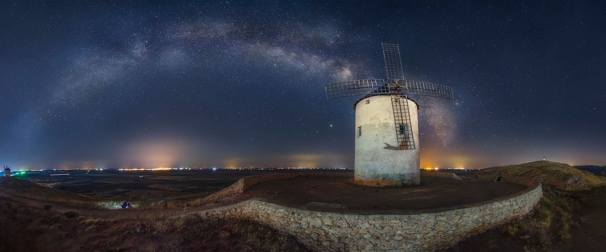 A windmill under a starry sky with the Milky Way visible.