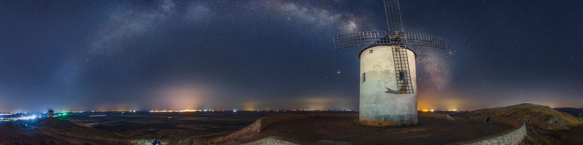 A windmill under a starry sky with the Milky Way visible.