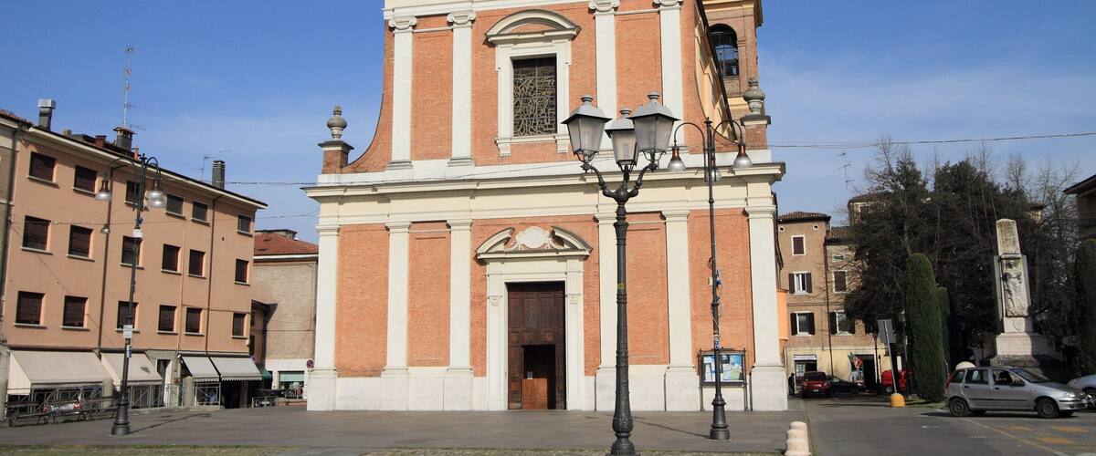 A historic church with a tall bell tower and a large arched window.