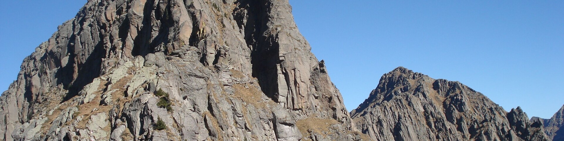 Una cordillera accidentada con riscos escarpados y vegetación escasa.