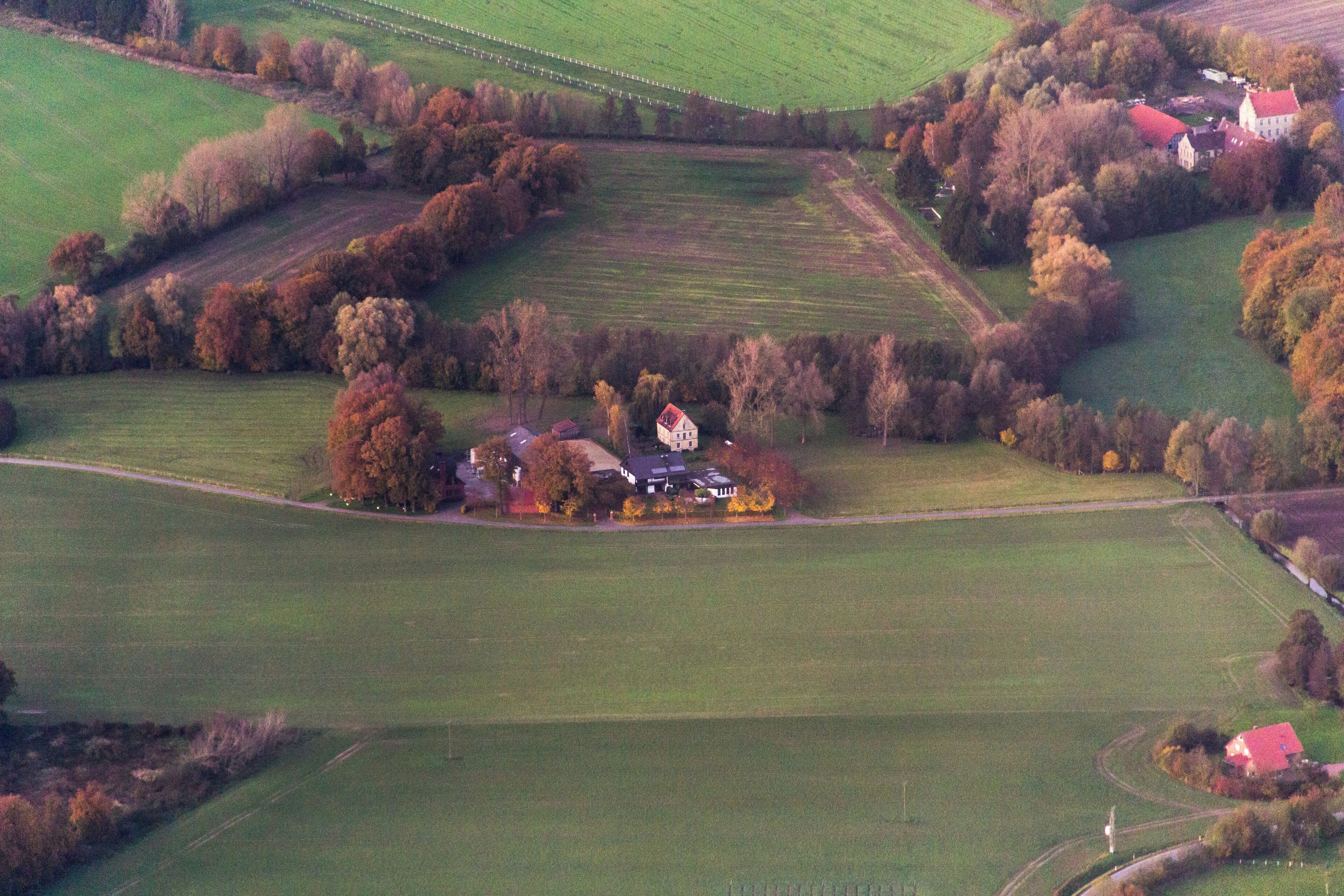 An aerial view of a rural landscape with fields, trees, and houses.