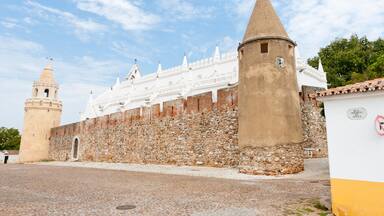 A historic fortress with white walls and a stone tower.