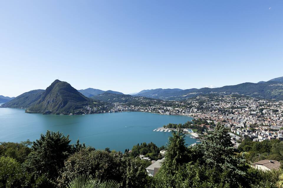 A coastal city with a prominent mountain, a large body of water, and dense urban development.