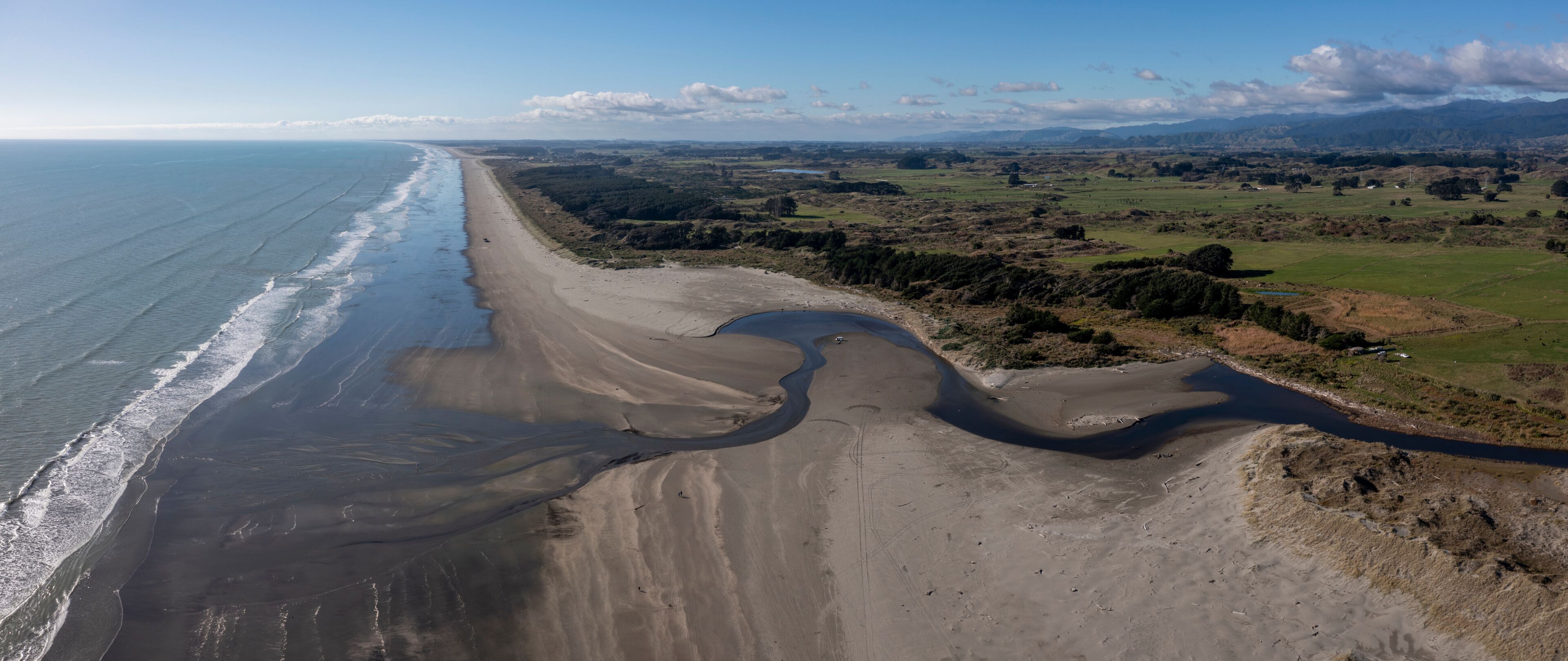 A panoramic aerial shot from Ōtaki Beach, on the Kapiti Coast of New Zealand, looking North with the Mouth of the Waitohu stream as it meets the Tasman Sea
