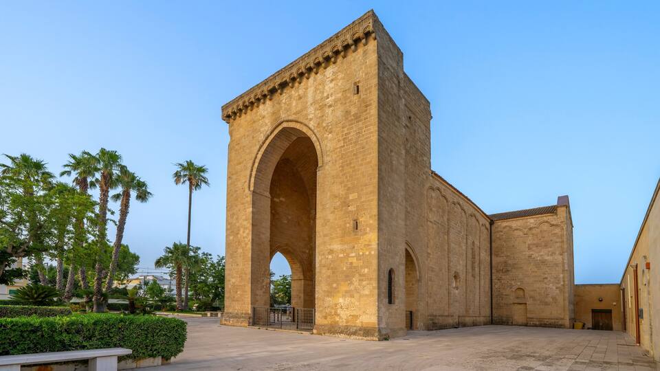 A historic stone building with an arched entrance and a courtyard.
