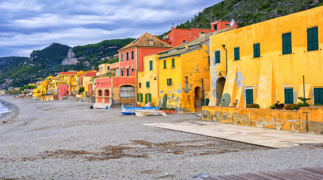 A coastal town with colorful buildings, a sandy beach, and a rocky hillside.