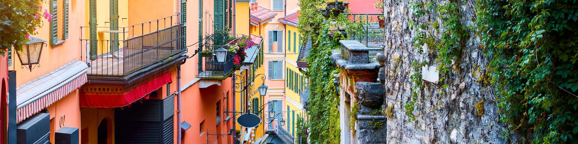 Bellagio, lake Como, Milan, Italy. Famous stone stairs street. Evening Nighttime with blue sky and lights of outdoor lanterns. Picturesque italian architecture famous luxury Alpine health resort