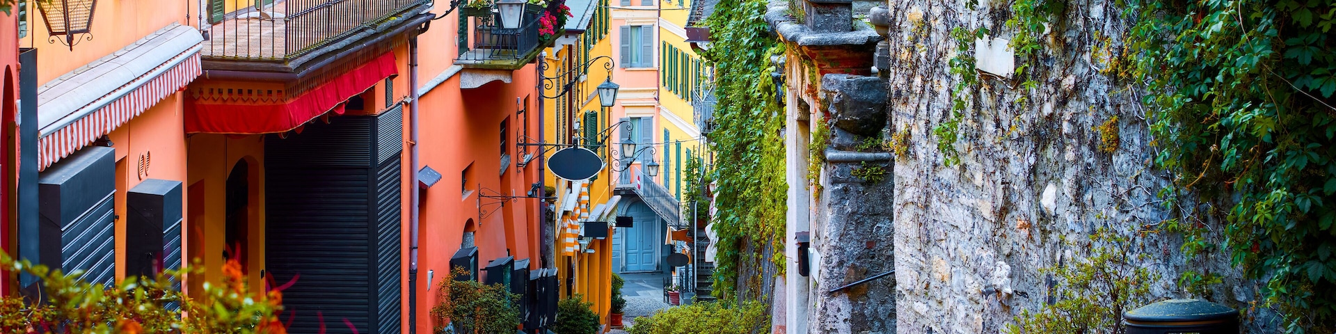 Bellagio, lake Como, Milan, Italy. Famous stone stairs street. Evening Nighttime with blue sky and lights of outdoor lanterns. Picturesque italian architecture famous luxury Alpine health resort