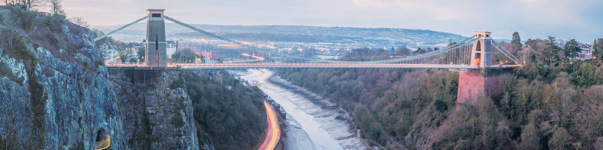 Cityscape panorama view of Bristol, England, UK and the Clifton Suspension Bridge above the Avon Gorge and River Avon at sunset or sunrise from St Vincent's Rocks.