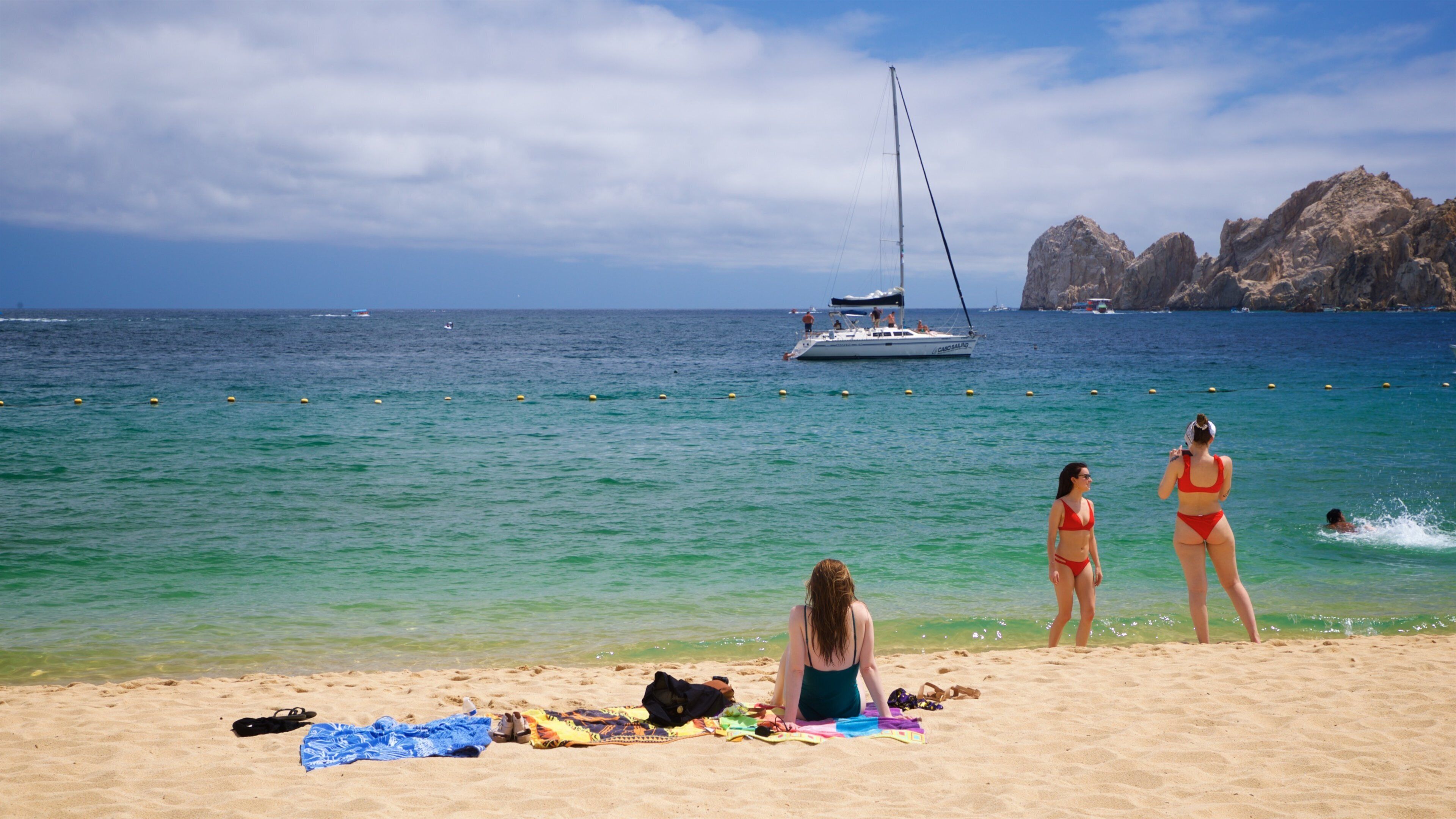 Medano Beach which includes a sandy beach and general coastal views as well as a small group of people