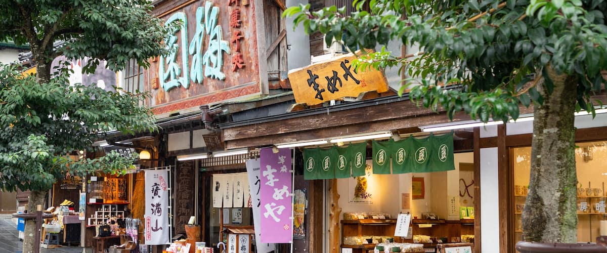 A traditional Japanese storefront with wooden signage and displays of goods.