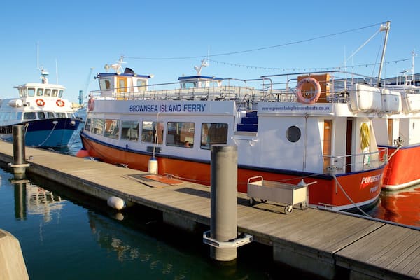 Eine Fähre liegt an einem Steg, wo weitere Boote vor Anker liegen.