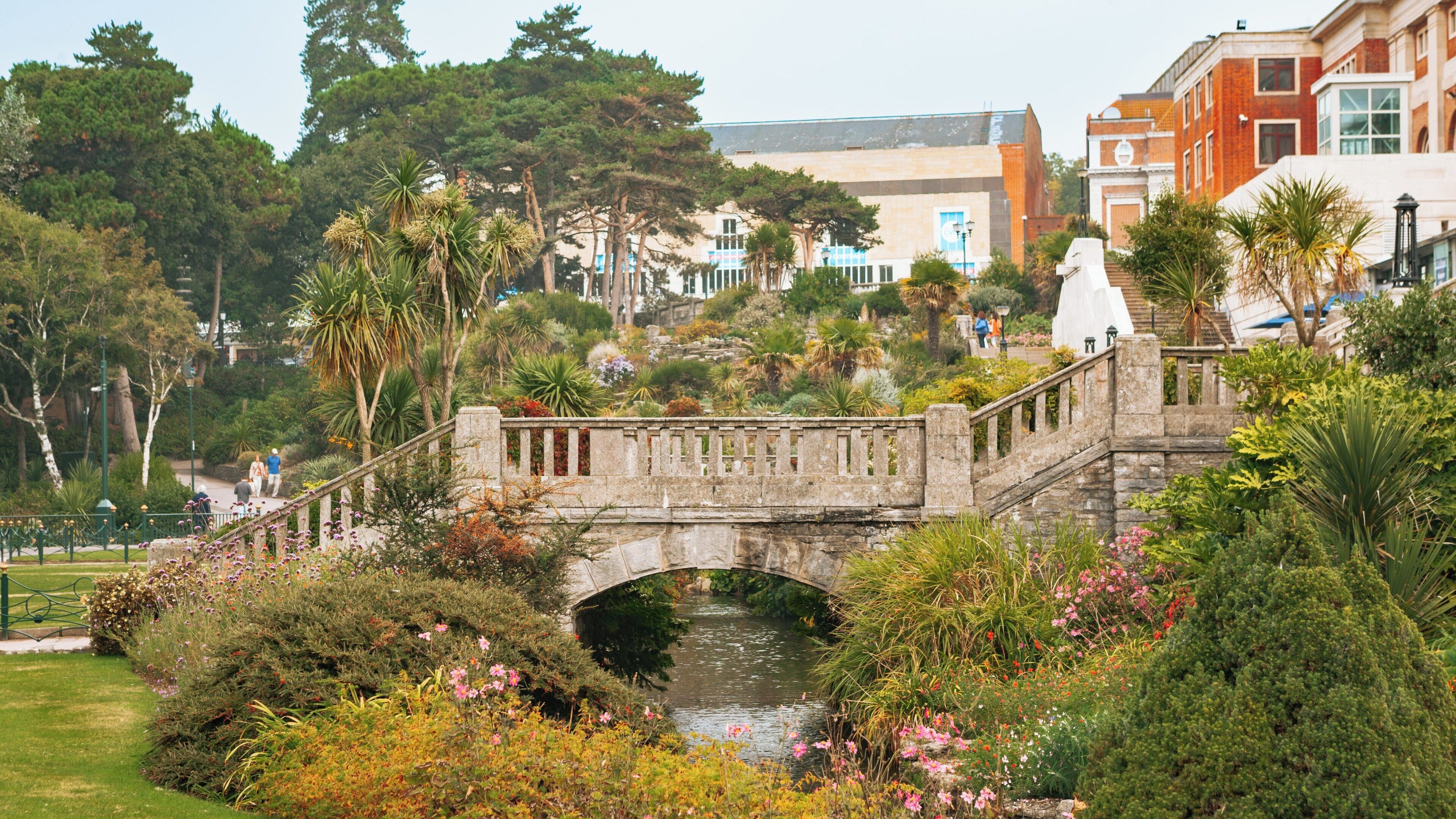 Explore the scenic beauty of Bournemouth Lower Gardens in Bournemouth City Centre, featuring lush greenery and a charming stone bridge