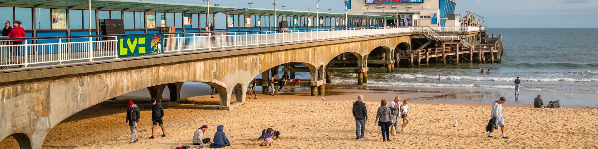 Bournemouth Pier showing general coastal views and a sandy beach as well as a small group of people