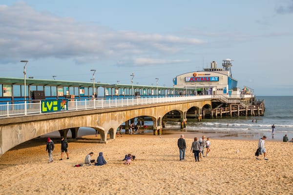 Bournemouth Pier showing general coastal views and a sandy beach as well as a small group of people