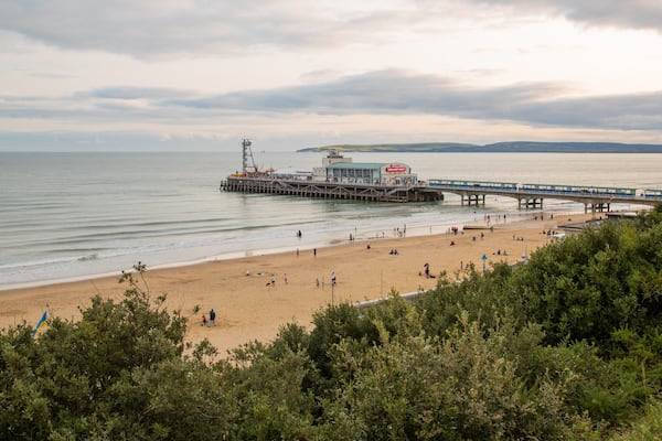 A beach with a pier and a lifeguard tower.