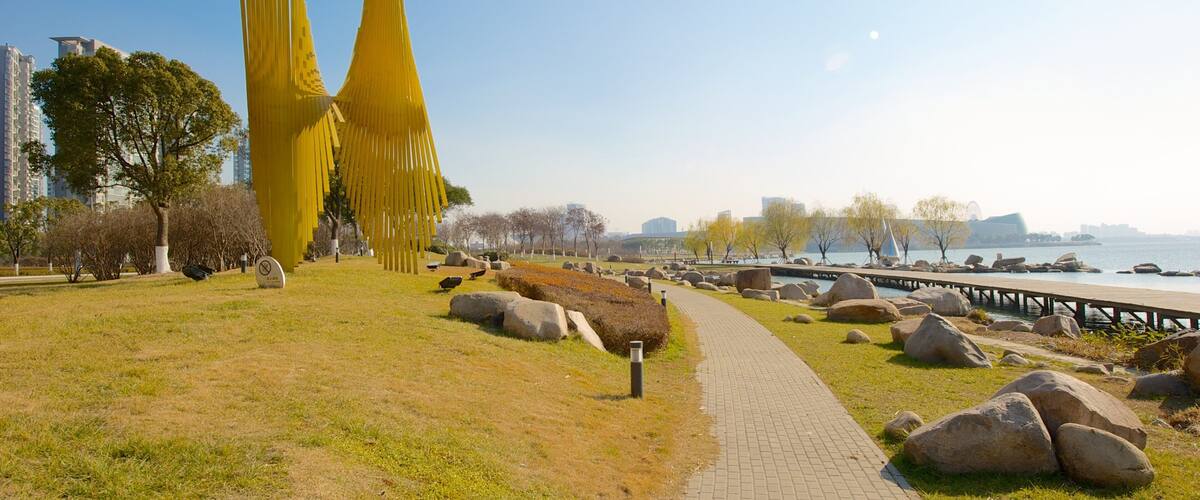 A park with yellow sculptures, a pathway, and a waterfront.