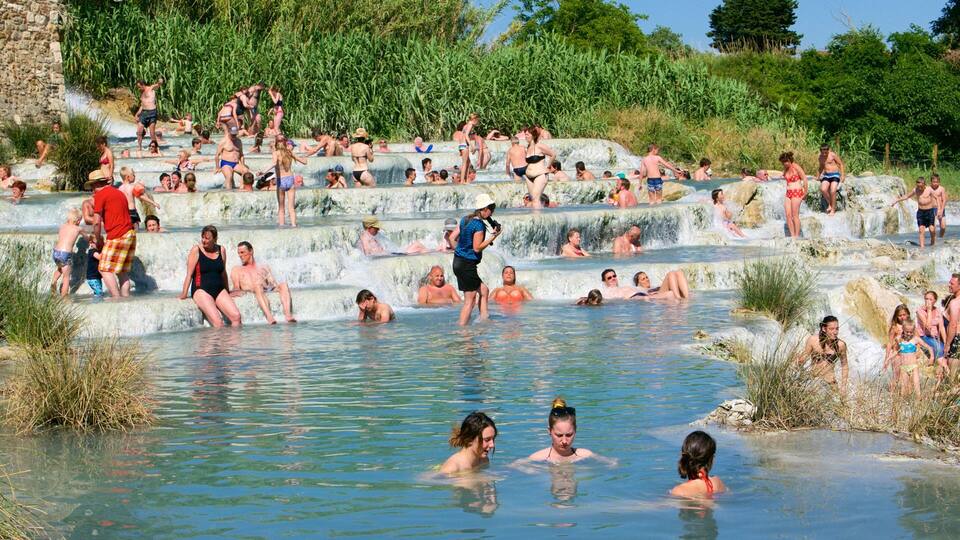 A natural hot spring with people relaxing in the water.