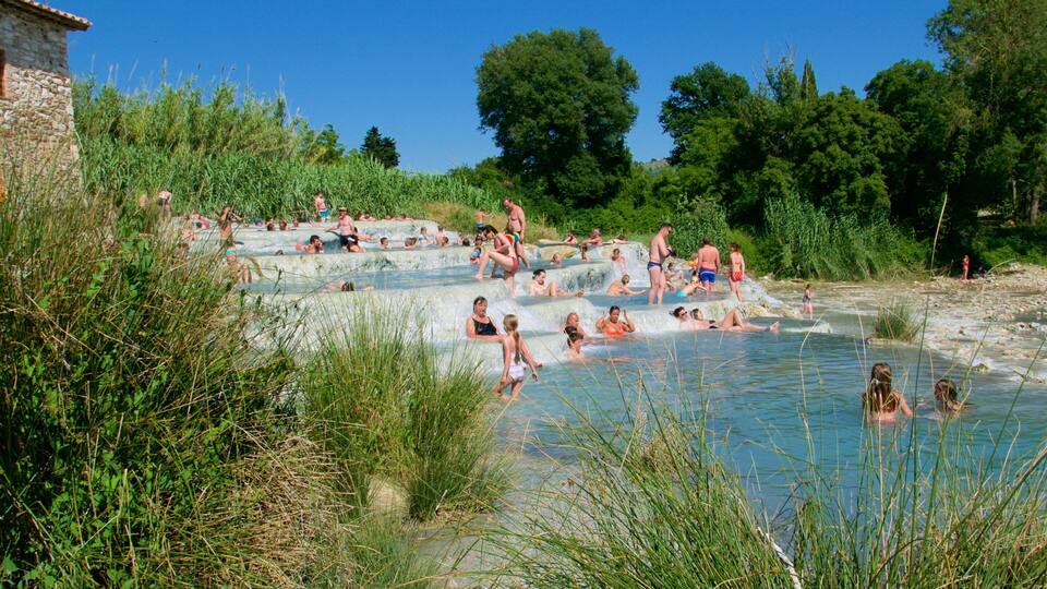 A natural hot spring with people relaxing in the water.