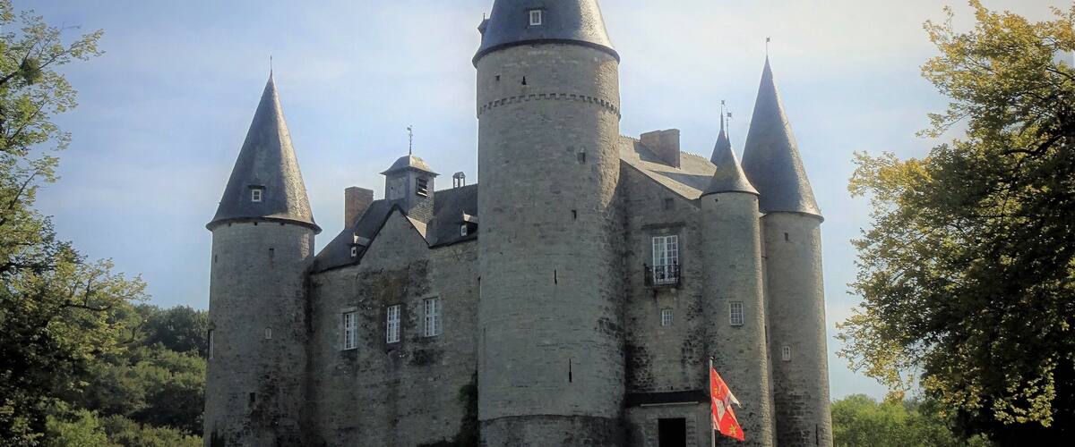 A medieval castle with multiple towers and a flag.