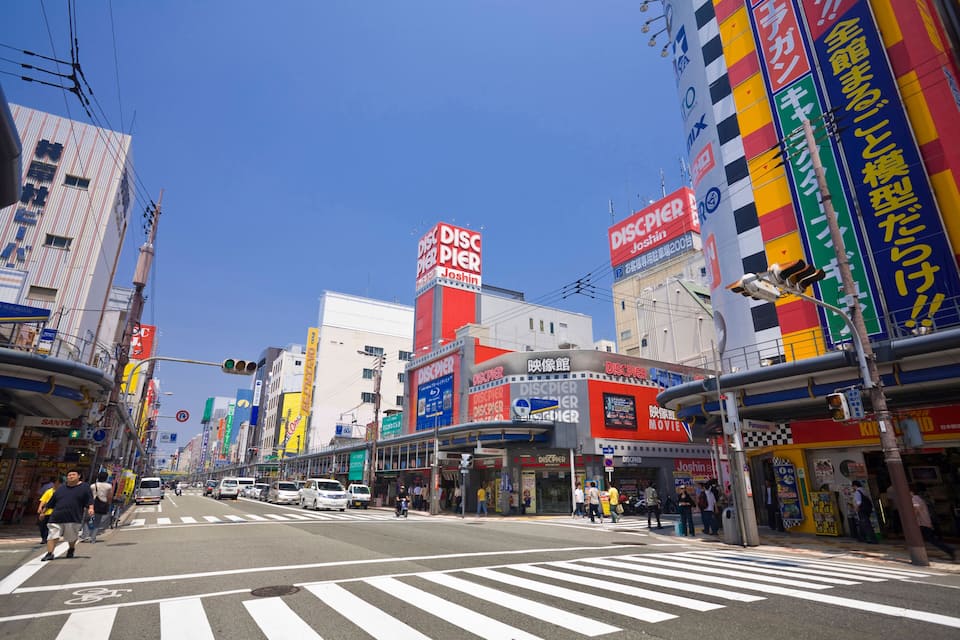 A busy urban street with a prominent DISCPIER cinema and various shops.