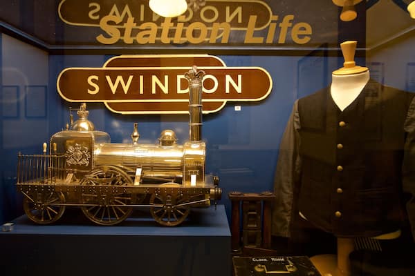 Ein Modellzug und eine Schaufensterpuppe in einer Vitrine.