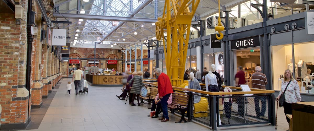 Swindon Designer Outlet featuring interior views and shopping as well as a small group of people