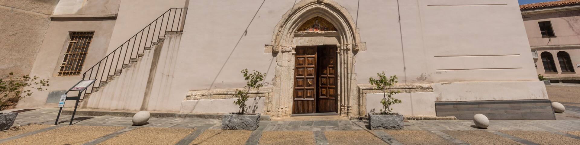 A church with a bell tower, a circular window, and a door with an arch.