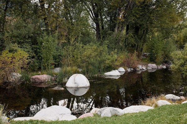 Pond surrounded by rocks and lush trees at the John Denver Sanctuary in Aspen, Colorado