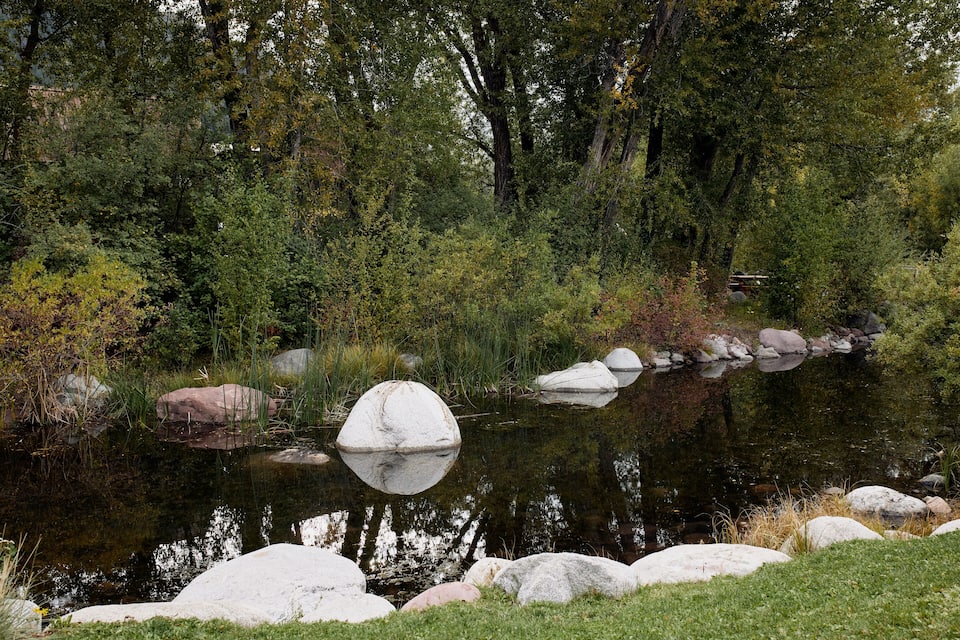 A pond surrounded by rocks and trees.