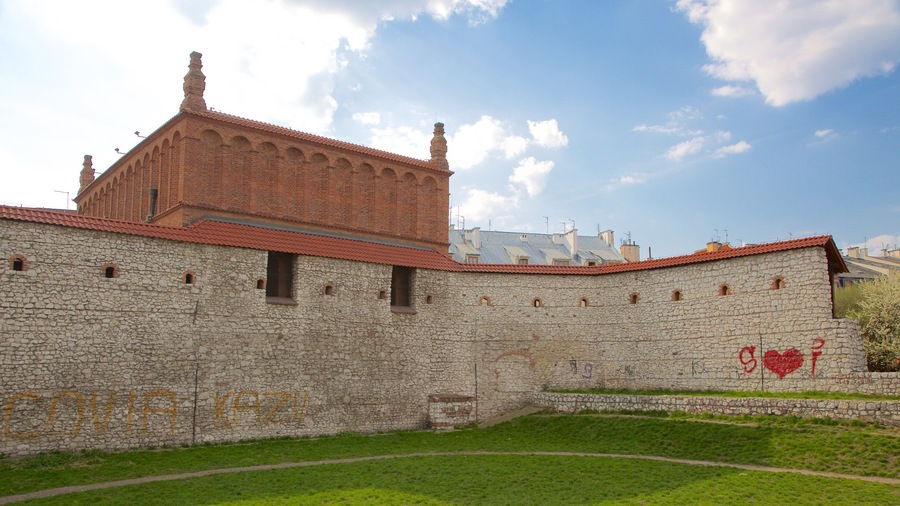 A historic stone wall with arched windows and a red-tiled roof.