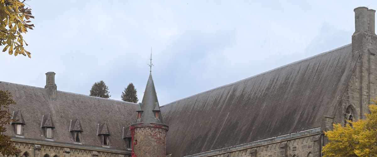 A historic building with a tall tower and ivy-covered walls.