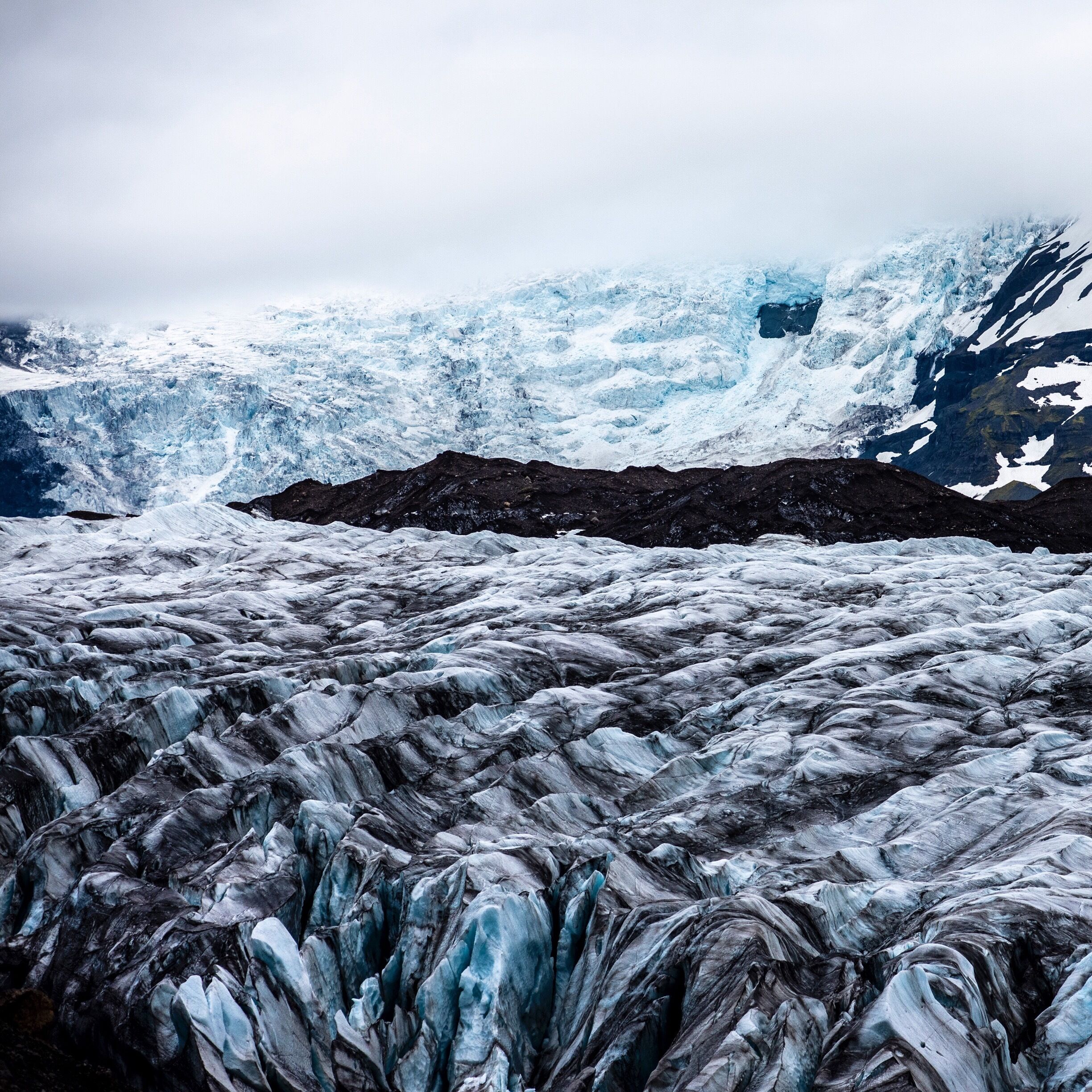 A glacier with ice formations and a mountain in the background.
