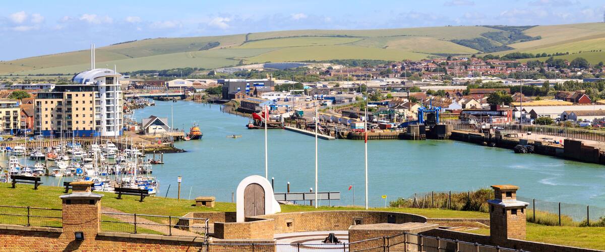 A harbor with boats, a bridge, and a town in the background.
