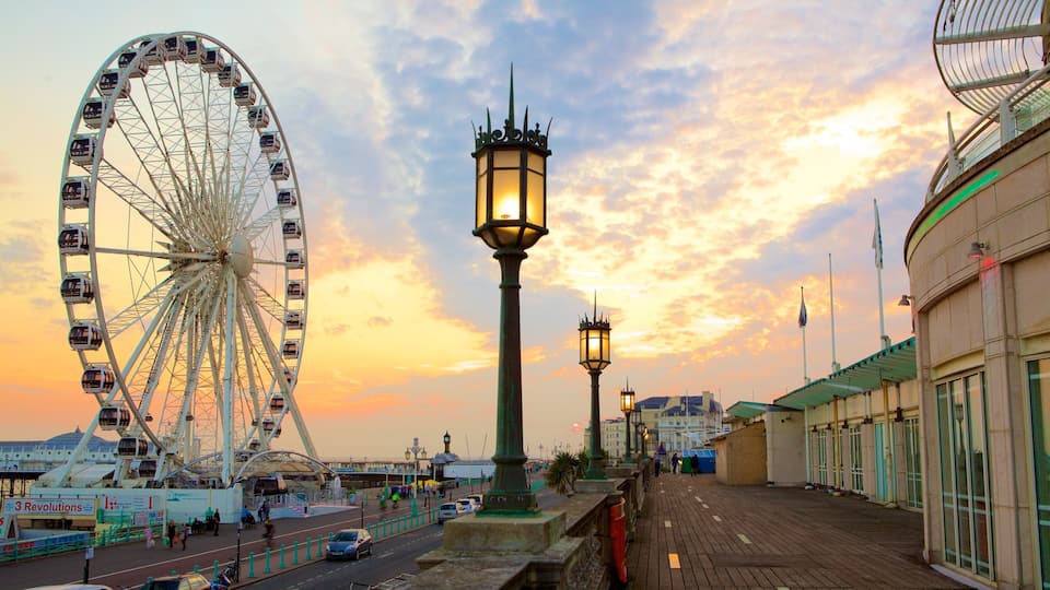 A Ferris wheel, a waterfront promenade, and a building with a green roof.