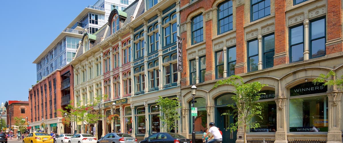 A street with historic buildings, cars, and a cyclist.