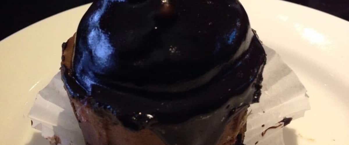 A dessert on a plate with a white cup labeled "Torrie" in the background.