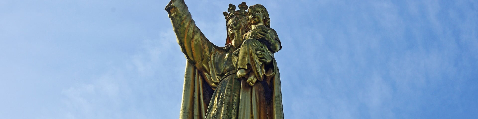 Argenton-sur-Creuse (Indre) Chapelle de la Bonne-Dame. A la fin du XIIe siècle une vaste forteresse, dotée de dix tours occupait presque deux hectares. "Pendant les guerres du moyen-âge, le château d'Argenton fut assiégé et pris plusieurs fois. Philippe Auguste s'en empara en 1188, et quatre cents après, le 15 mars 1589, Henri IV, dans une de ses lettres, manifeste toute sa joie d'avoir pu prendre miraculeusement une place aussi forte que l'était ce château. (...) Dès l'année 1564, l'intérieur du château n'offrait p^lus que des ruines, tandis que ses énormes tours présentaient encor un front redoutable. (...) Sous le ministère de Richelieu, la destruction du vieux château d'Argenton fut résolue, et des lettres patentes de Louis XIII, du 11 juillet 1632, ordonnèrent la levée des 20 000 livres nécessaires pour subvenir aux frais de cette démolition. Vingt ans plus tard, le parlement cherchant à renouveler les troubles de la Fronde, ordonna de fortifier de nouveau le château d'Argenton, auquel on travailla en 1630 et 1651; mais Louis XIV donna enfin l'ordre de faire sauter tout ce qui restait de ces fortifications." (Dictionnaire géographique, historique, industriel et commercial de toutes les communes de France et de plus de 20,000 hameaiux en dépendant. Par A Girault de Saint Fargeau - 1844) Seule la chapelle castrale fut gardée. La Chapelle de "La bonne Dame" est un reste très remanié, à la fin du 19e siècle, par l'architecte parisien Alfred Trolliet*, de l'ancienne chapelle castrale. La statue de la Bonne-Dame d'Argenton , l'Enfant Jésus sur son bras gauche, étend son bras droit sur la ville, faisant écho à la phrase sur le portail : Posuerunt me custodem, « Ils m'ont placé là pour les protéger ». Cette statue, réalisée en cuivre rouge, avec une charpente intérieure en fer, dorée à la feuille par la Société française d'ornements de Paris est montée en juillet 1899 sur le clocher de la nouvelle chapelle. La statue mesure 6,5 mètres de hauteur et pèse 3 tonnes. On doit à Alfred Trollier l'immeuble des 23 et 25 rue du Capitaine Lagache dans le 17ème à Paris, contruit en 1890.