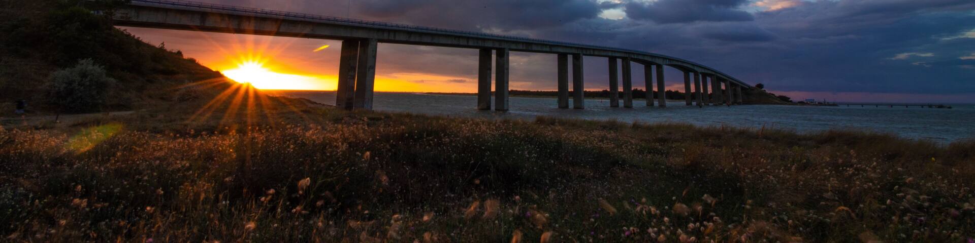 Sunset under the bridge to Noirmoutier, France, with frozen fast-moving clouds