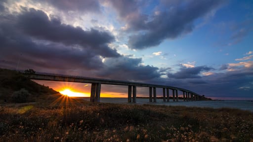 Sunset under the bridge to Noirmoutier, France, with frozen fast-moving clouds