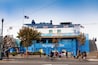 A building with the sign "Aquarium Bay" and multiple American flags.