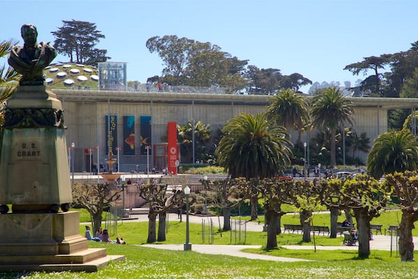 Ein Park mit einer Statue, Palmen und einem Gebäude mit Bannern.