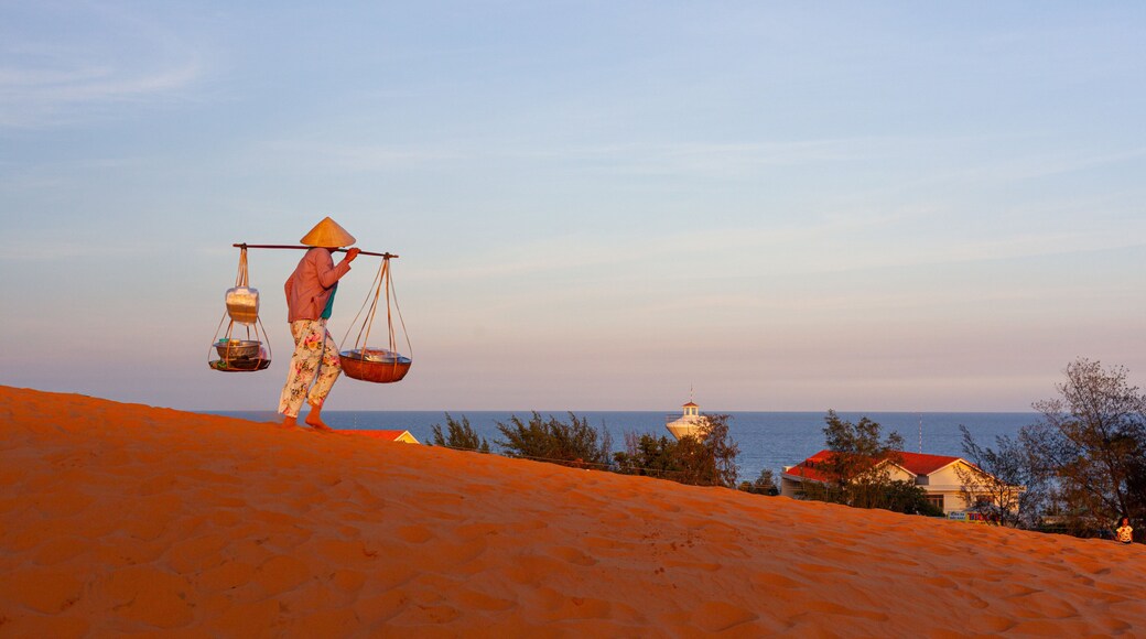 Mui Ne Sand Dunes which includes a sandy beach and a sunset as well as an individual femail
