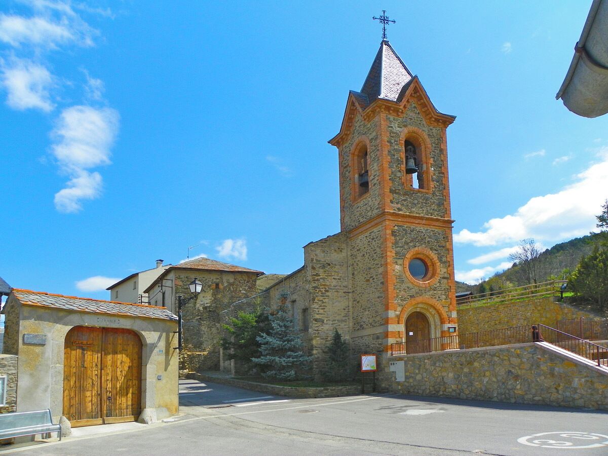 A stone church with a bell tower and a wooden door.