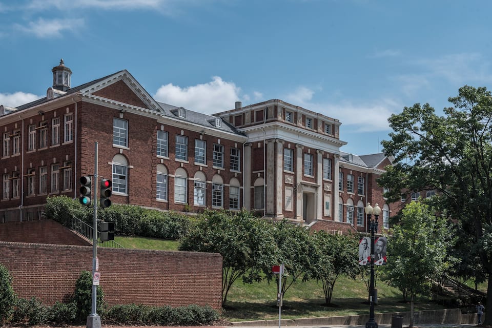 A large brick building with columns and arched windows.