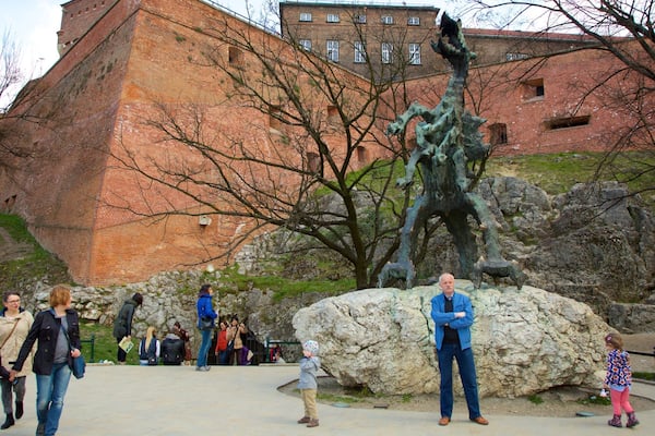 Drachenhöhle welches beinhaltet Statue oder Skulptur sowie kleine Menschengruppe