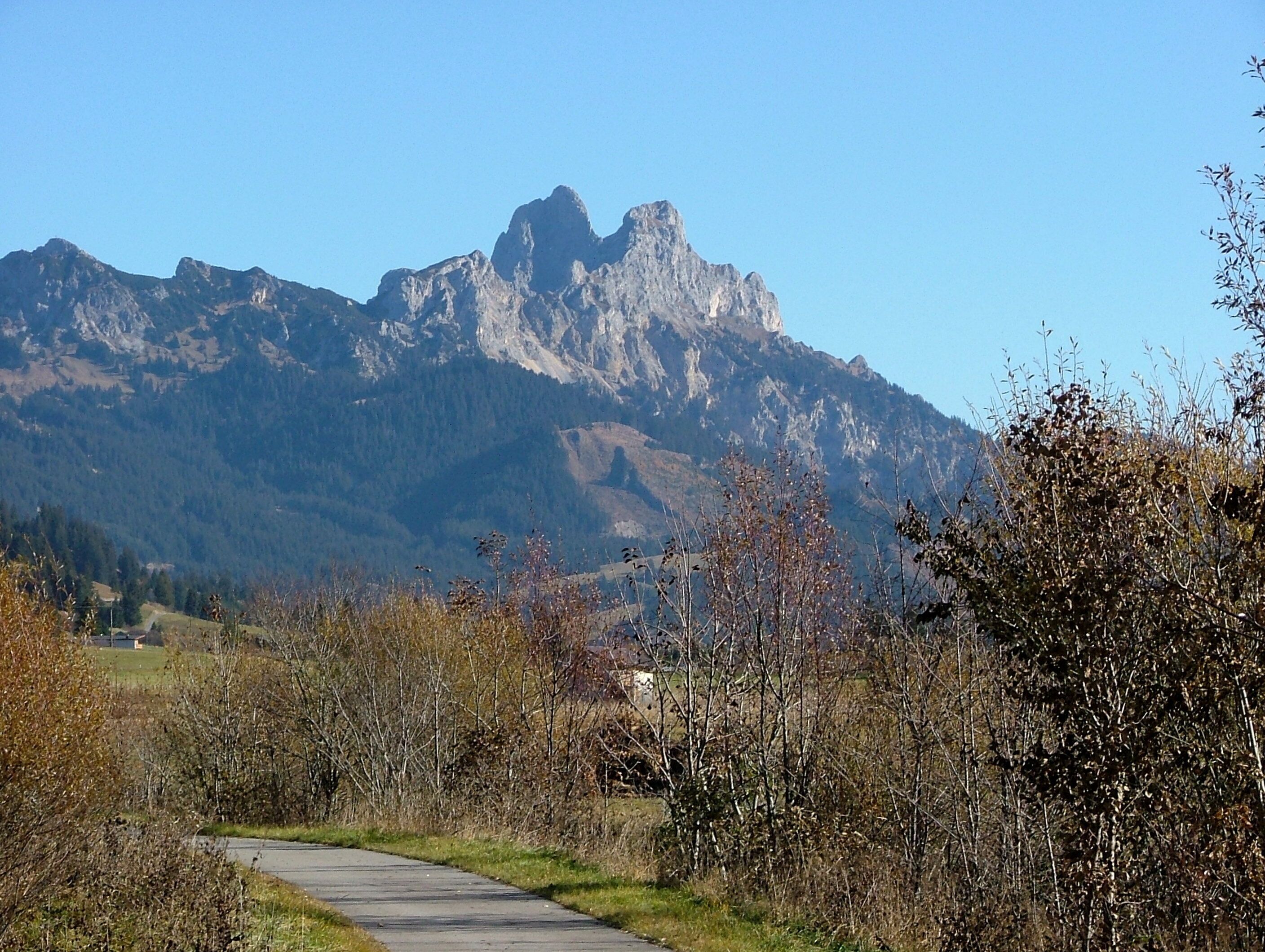 A mountain path with a view of rugged mountains in the background.