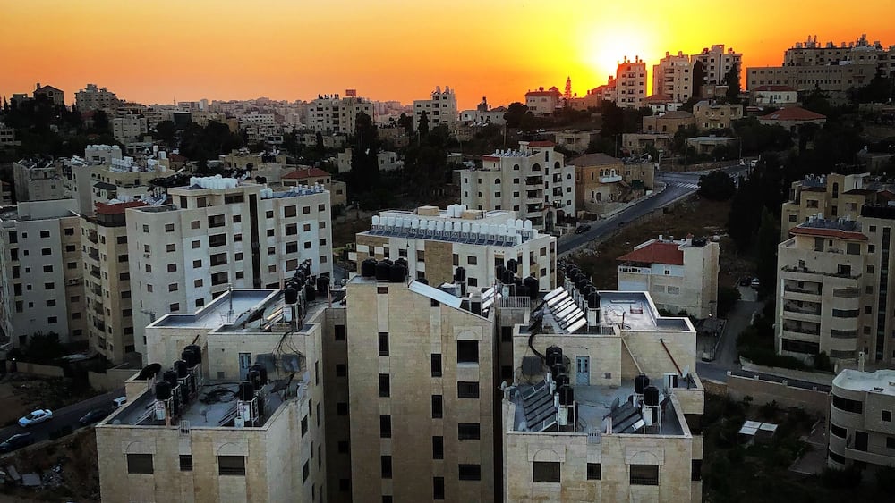 A cityscape at sunset with multiple high-rise buildings and a clear sky.