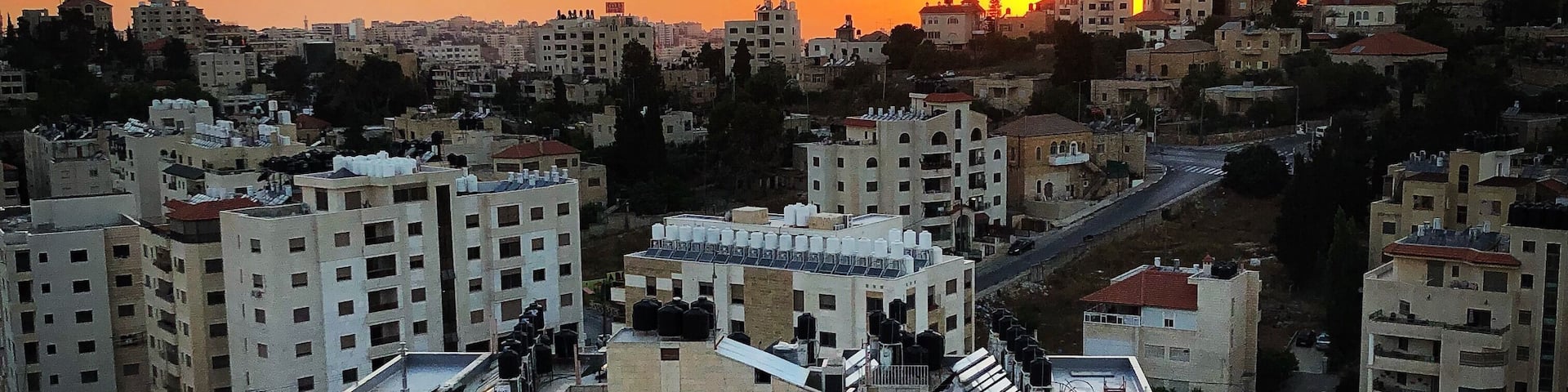 A cityscape at sunset with multiple high-rise buildings and a clear sky.