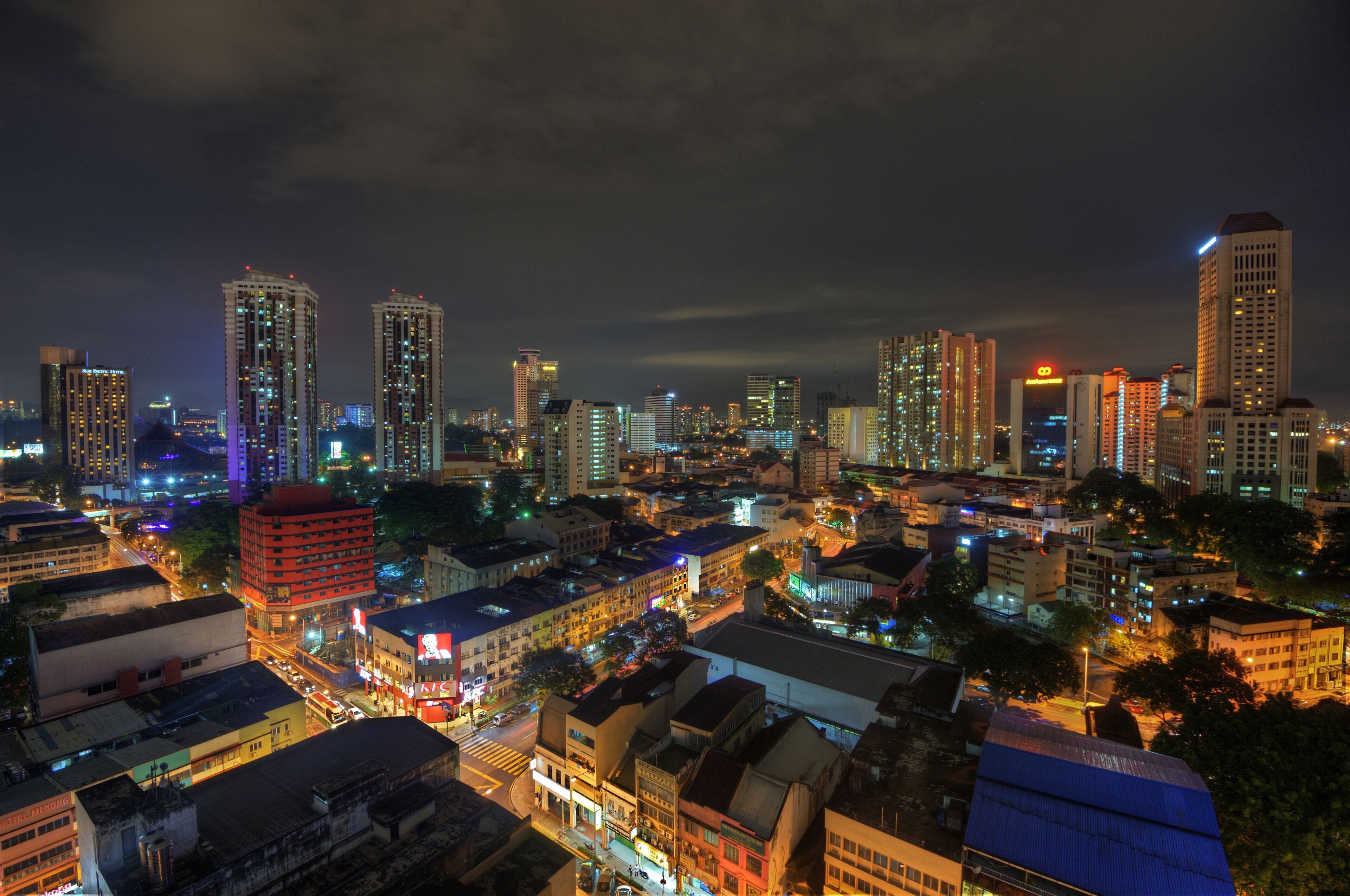 A cityscape at night with illuminated buildings and streets.